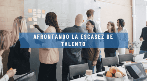 Grupo de profesionales reunidos en una sala de trabajo, discutiendo ideas y estrategias con la frase "Afrontando la escasez de talento" sobre un fondo azul. onhunters, firma de búsqueda y selección de personal.