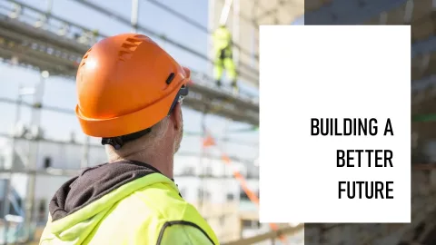 Trabajador de la construcción con casco naranja observando obra en construcción, simbolizando la construcción de un futuro mejor. onhunters, firma de búsqueda y selección de personal