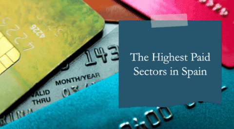Primer plano de varias tarjetas de crédito de diferentes colores superpuestas, con un recuadro azul que contiene el texto "The Highest Paid Sectors in Spain". onhunters, firma de búsqueda y selección de personal.