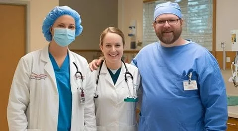 Equipo de profesionales sanitarios sonrientes con uniforme médico en un entorno hospitalario. onhunters, firma de búsqueda y selección de personal.