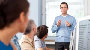 Formador explicando un proceso a un grupo de trabajadores logísticos en aula corporativa