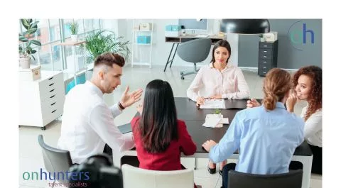 Equipo de consultores reunidos en sala de trabajo, analizando procesos de selección. onhunters, firma de búsqueda y selección de personal.