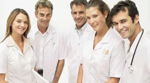 Grupo de profesionales sanitarios sonriendo en bata blanca, representando equipos médicos cohesionados. onhunters, firma de búsqueda y selección de personal.