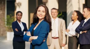 Grupo de profesionales de negocios con una mujer líder en primer plano, representando liderazgo y confianza en el equipo – onhunters, firma de búsqueda y selección de personal.