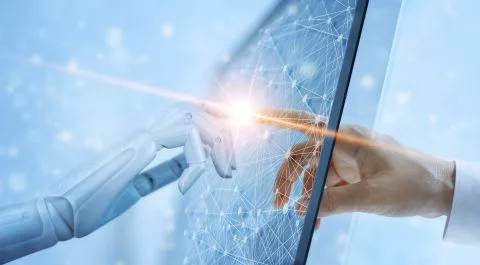 "Una mano humana y una mano robótica tocándose a través de una pantalla digital, representando la conexión entre tecnología y talento STEM en el mercado laboral." onhunters, firma de búsqueda y selección de personal.