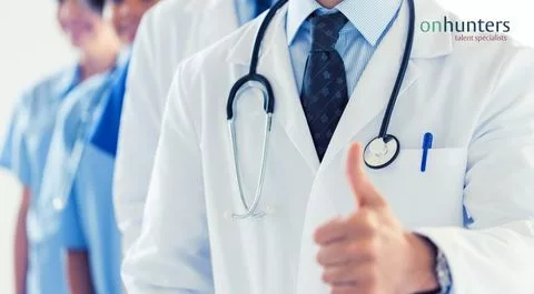 Un grupo de jóvenes médicos con batas blancas en un hospital.